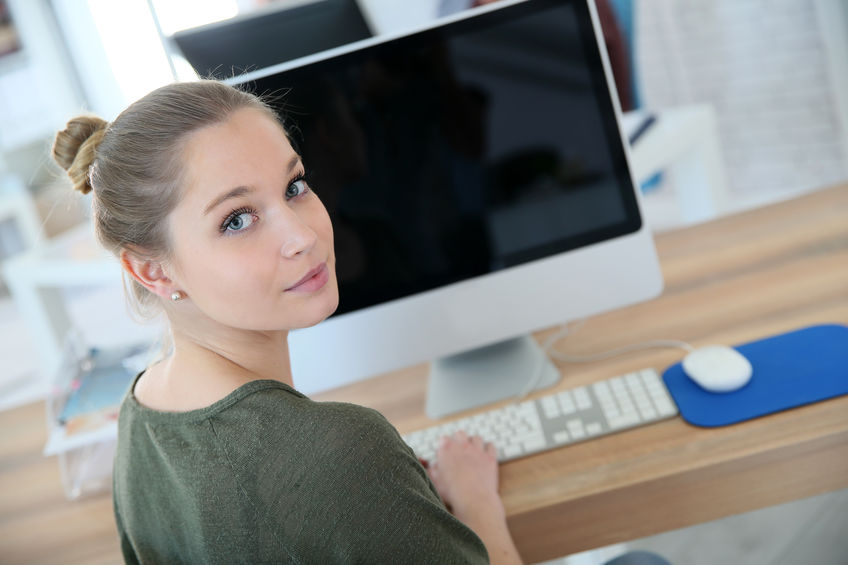 Portrait of student girl sitting in front of desktop